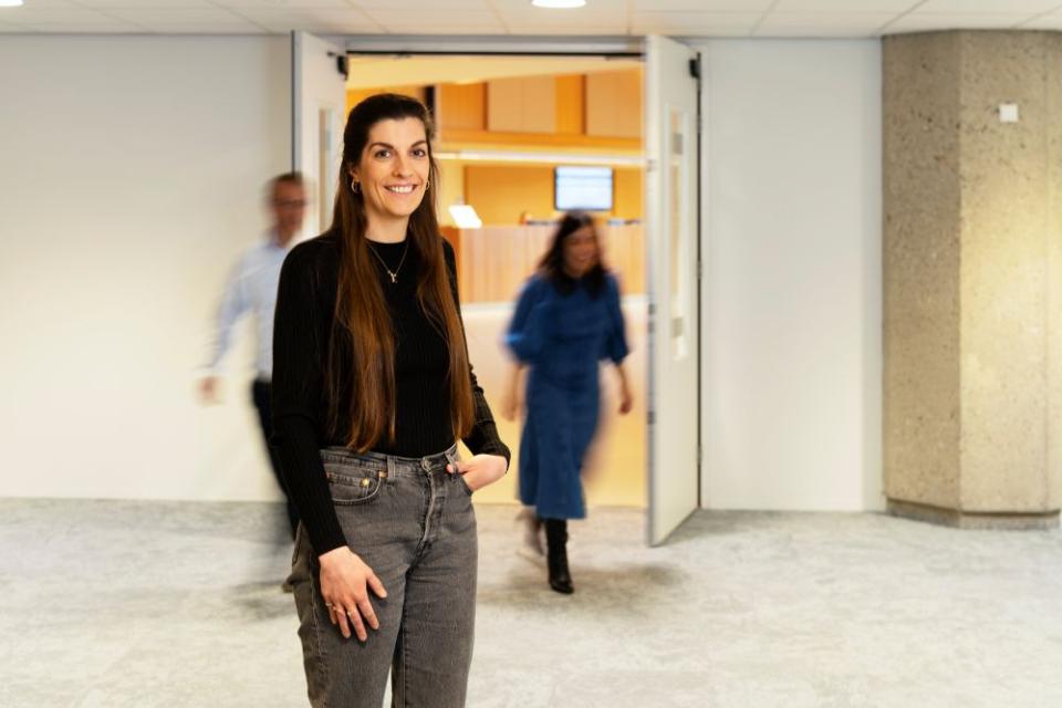 Woo jurist kijkt in de lens met 2 medewerkers op de achtergrond